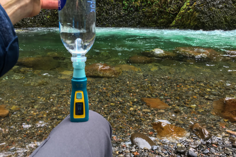 A hiker using the Katadyn Ultra Water Filter at the river