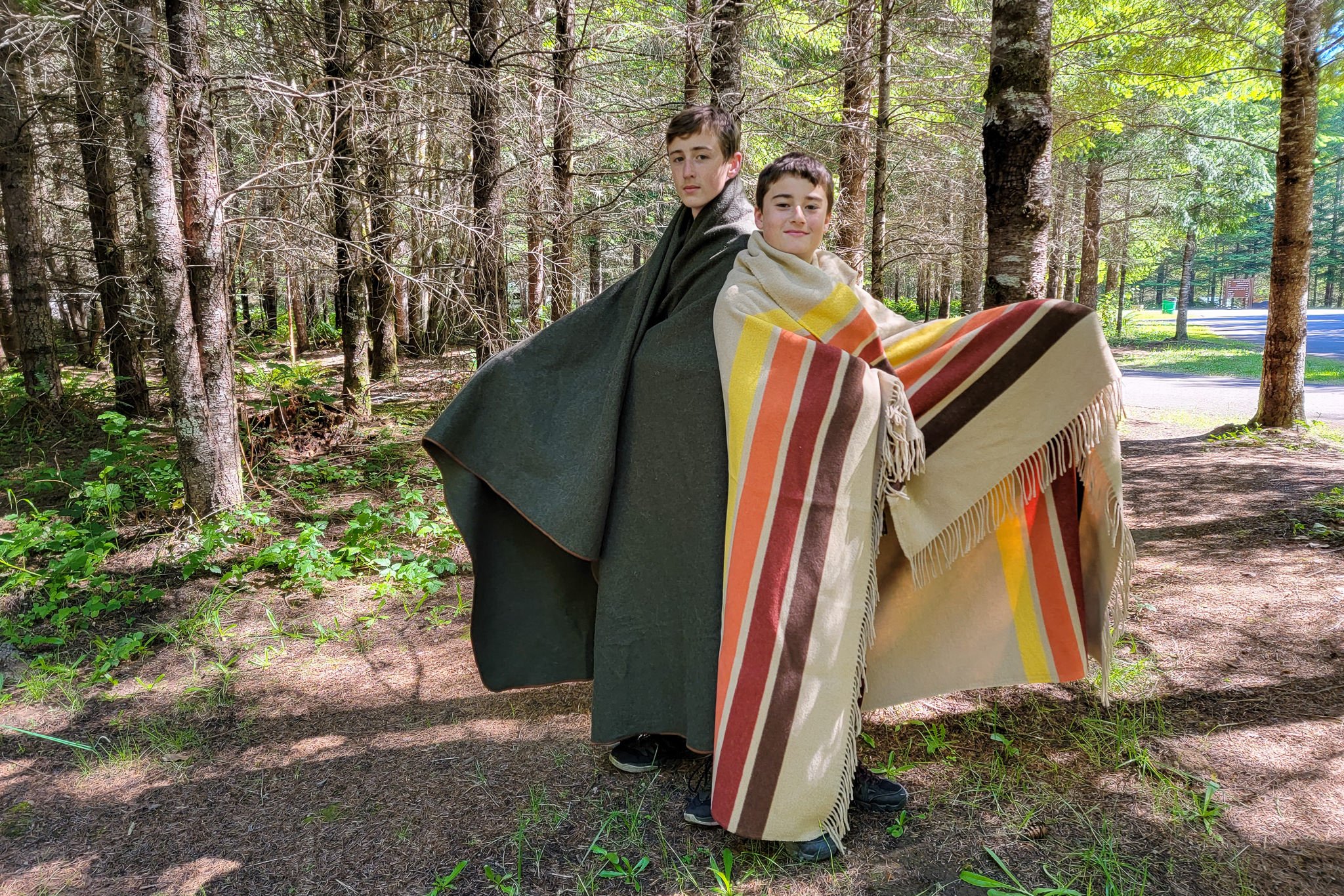 Two boys using the EKTOS 100% Wool and Sackcloth & Ashes blankets in camp
