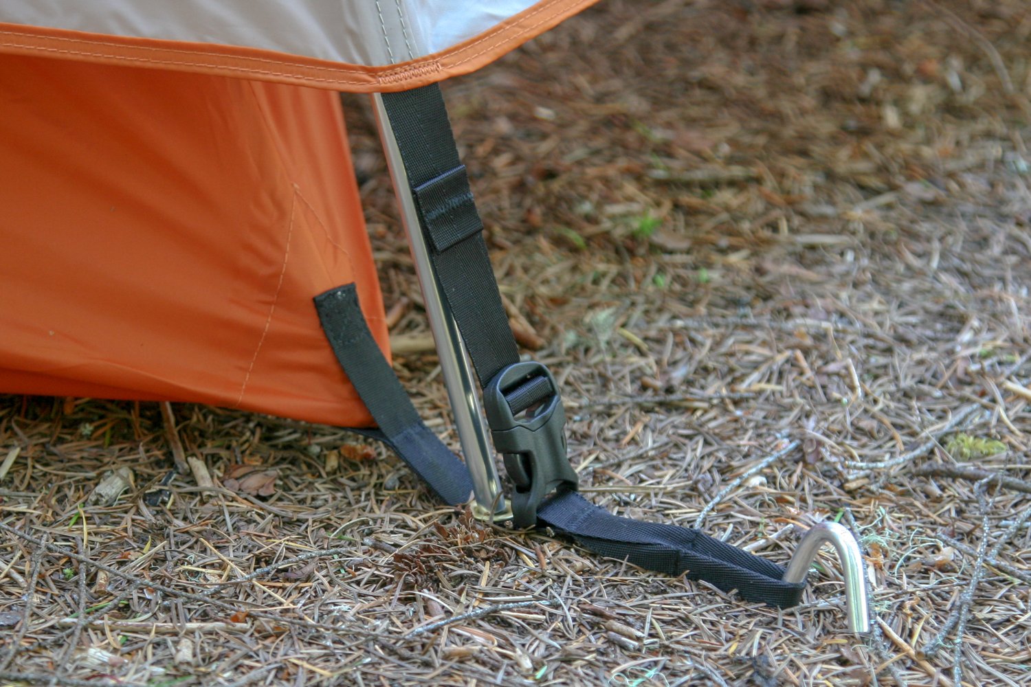 An aluminum hook tent stake holding down a camping tent