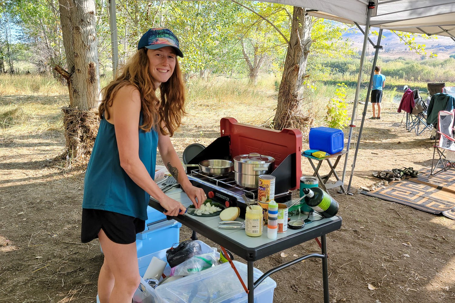 A woman chopping onions on a camping table