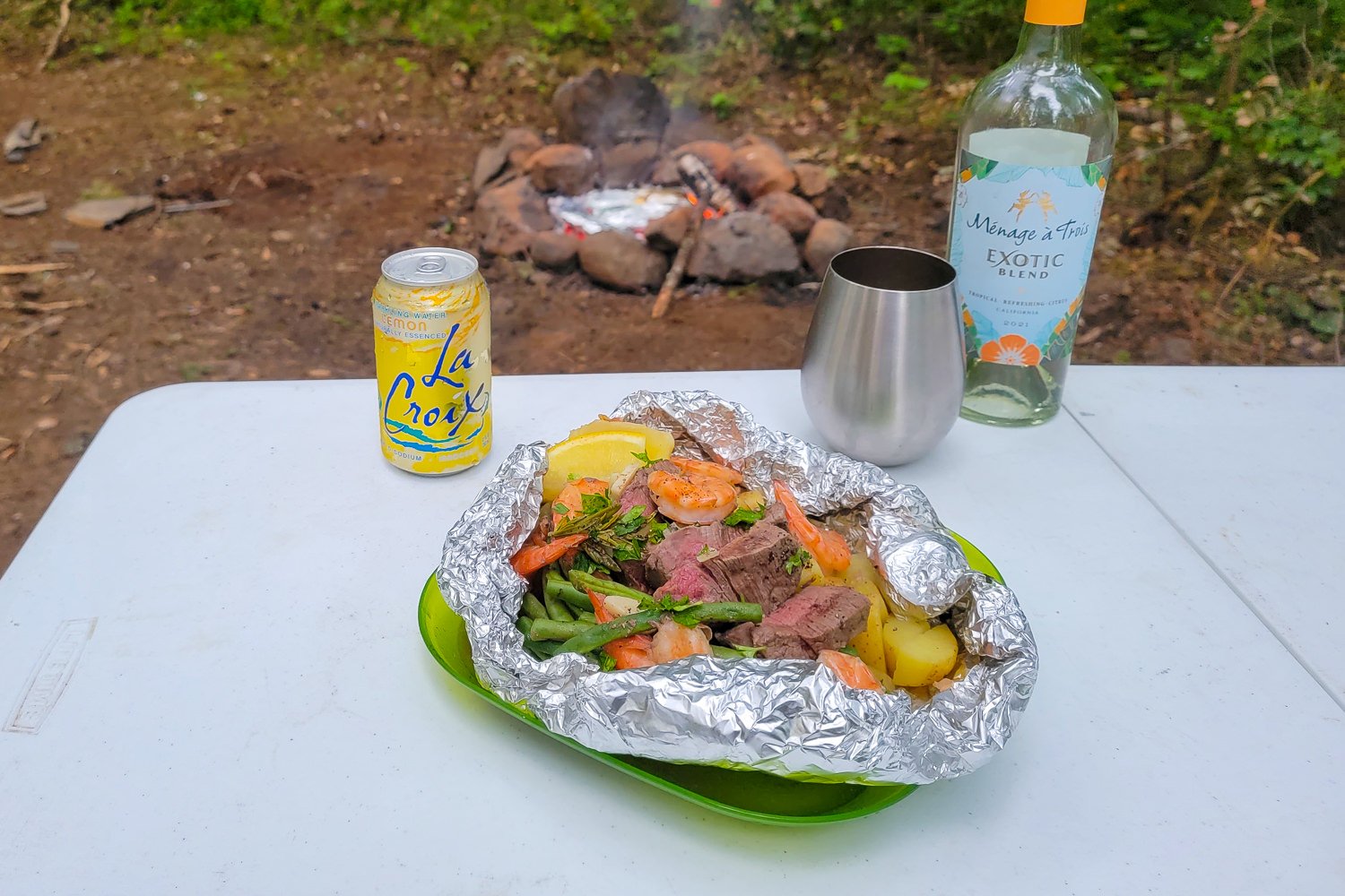 Surf and turf foil packet meal with lemon La Croix and white wine