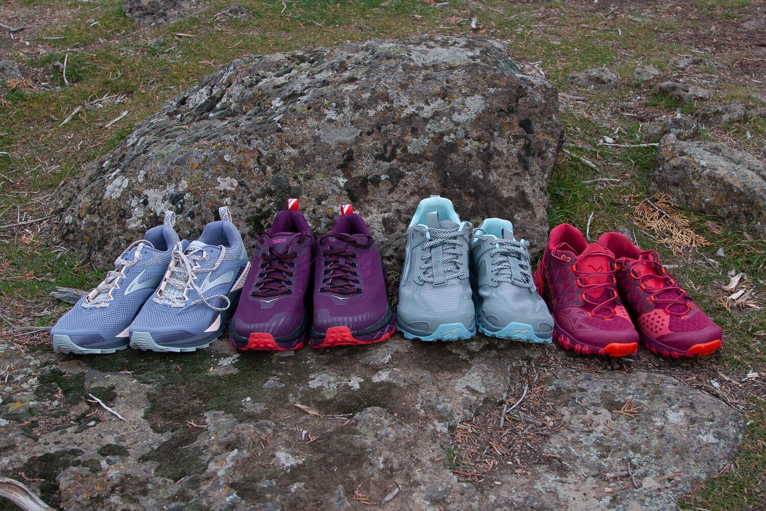 Four pairs of trail running shoes side-by-side for comparison.