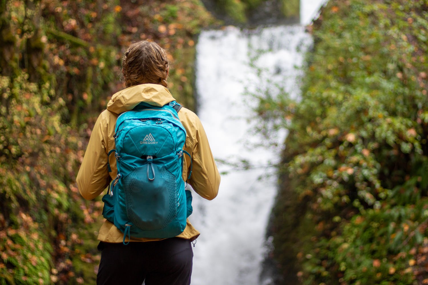 A hiker using the Gregory Juno 24 H20 hydration pack on a waterfall dayhike