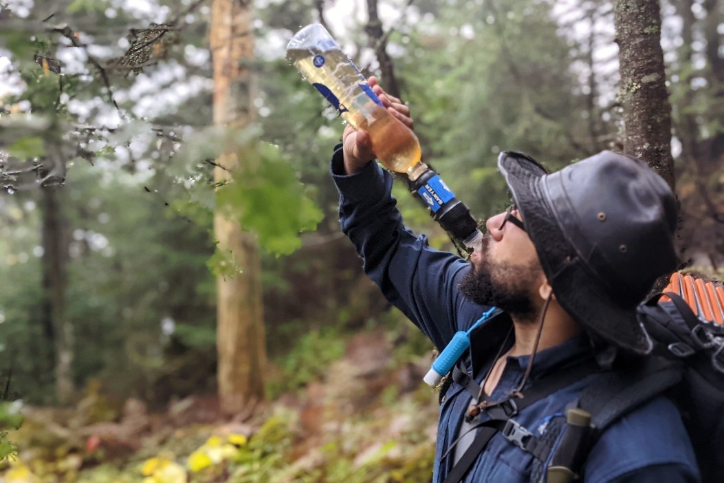 A hiker drinking out of a sawyer squeeze filter