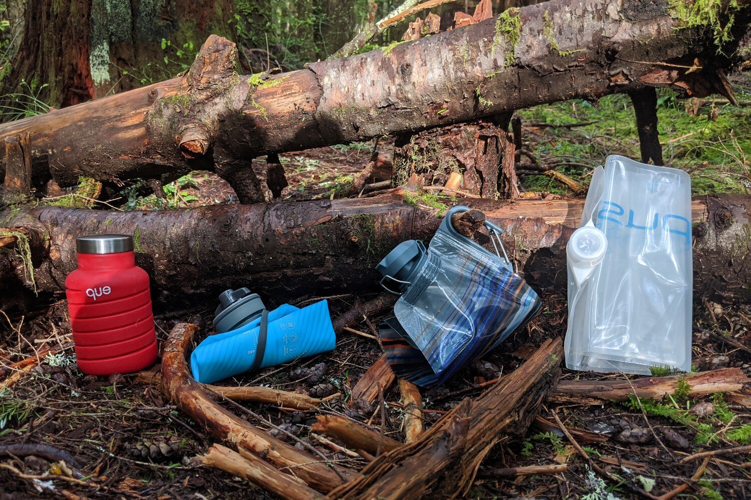 Comparing the best collapsible water bottles (from left to right): Que Collapsible Bottle, Hydrapak Flux, Platypus Softbottle with DuoLock Cap, and Platypus Platy Bottle.