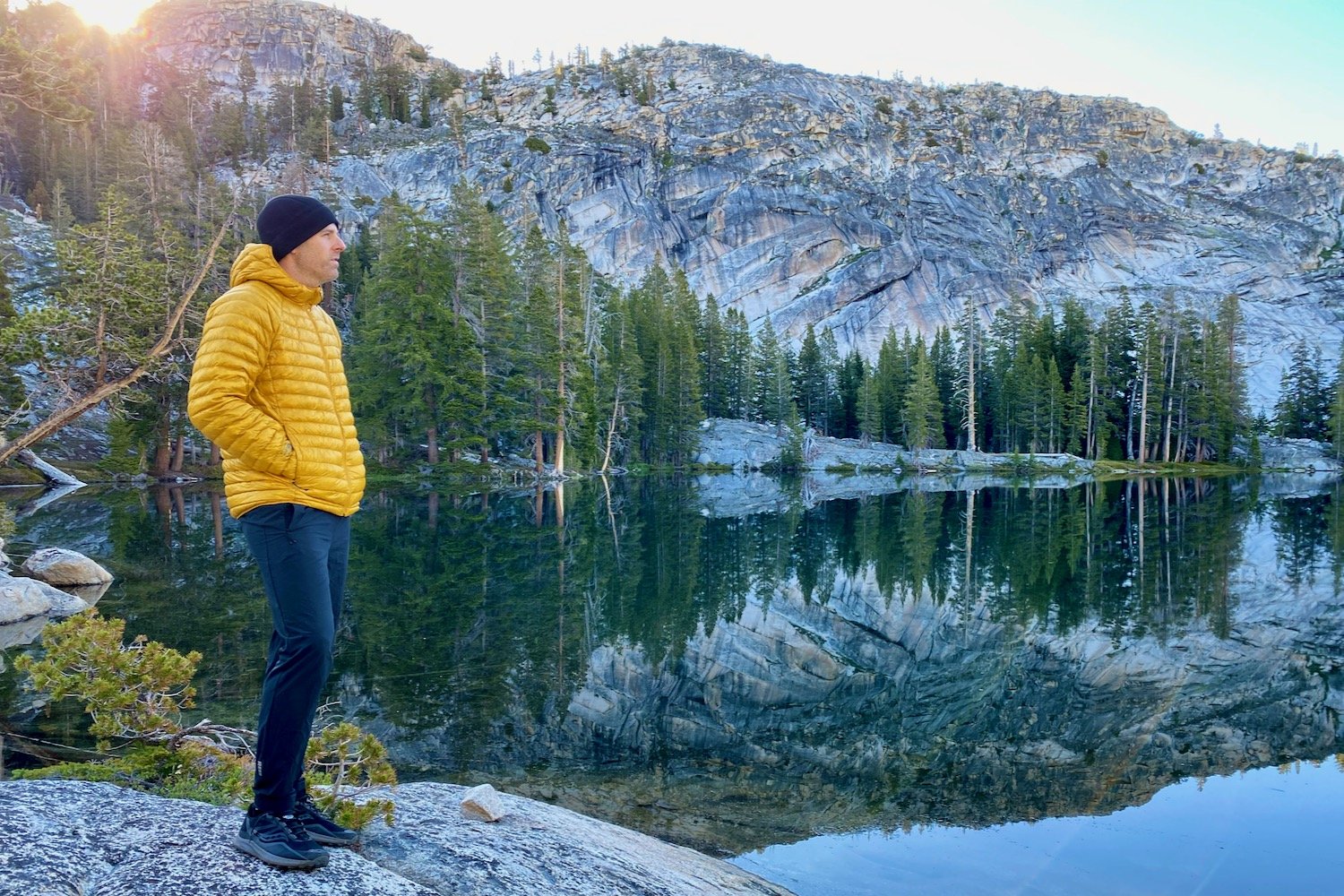 A backpacker wearing the The Mountain Hardwear Ghost Whisperer UL Down Jacket in Yosemite